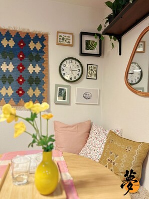 A room with a clock, framed botanical prints, a hanging plant, and a yellow vase with flowers. - Open Sale】 YUME Yume Matsuyacho 201 ｜Namba/Shinsaibashi area｜Walking distance from the station｜Family welcome (大阪市)