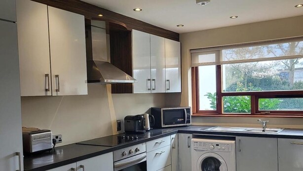 A modern kitchen with white cabinets, a microwave, a toaster, an oven, and a washing machine. - Luxury 2 Bed Lodge, Beside Castlemartyr Resort (Castlemartyr)