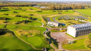 An aerial view of a golf course with a large building, winding roads, and surrounding greenery. - Luxury 2 Bed Lodge, Beside Castlemartyr Resort (Castlemartyr)
