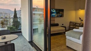 Ein modernes Wohnzimmer mit einer Couch, einem Esstisch und einem Fernseher.