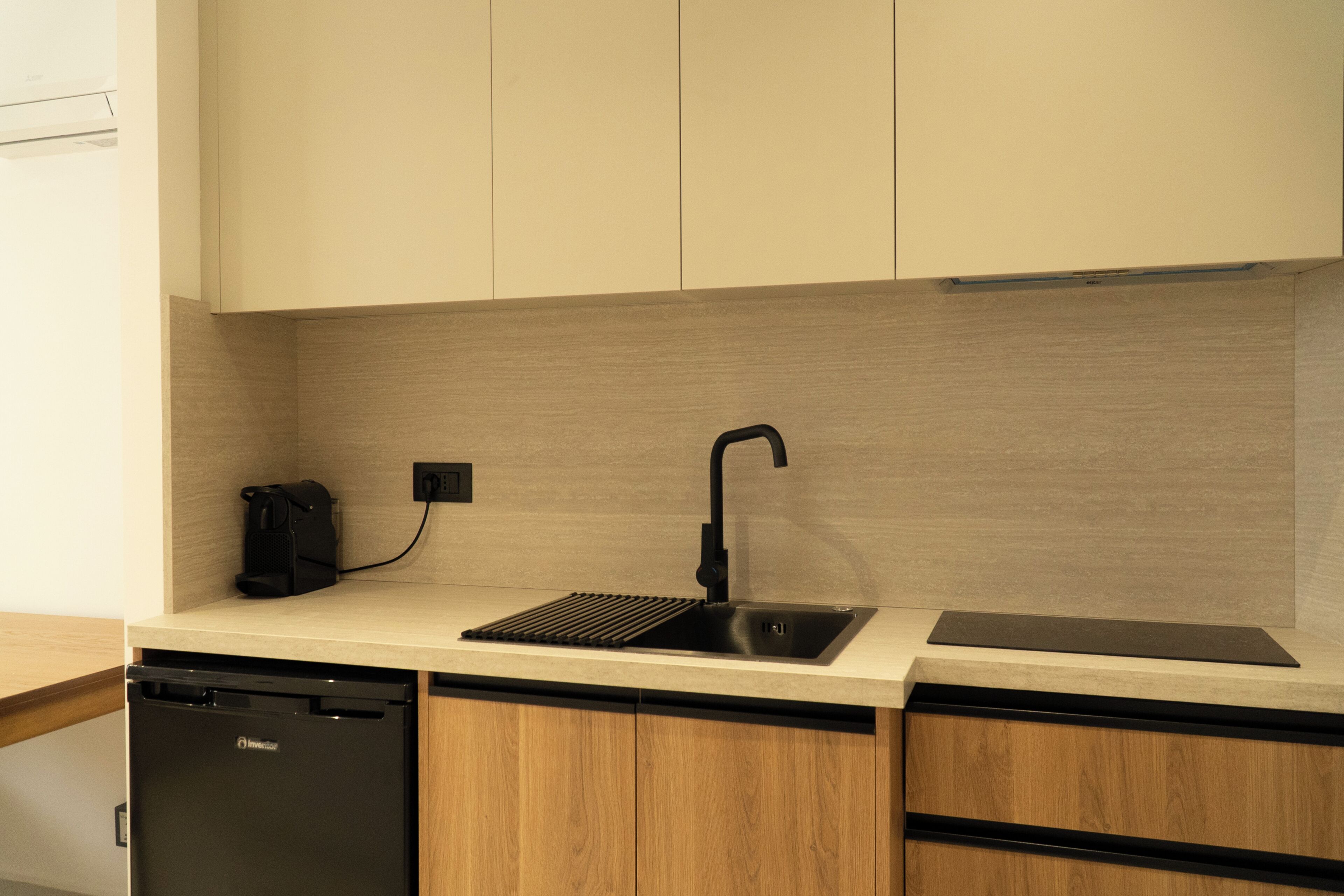 A modern kitchen with a dishwasher, a sink, and a coffee machine.