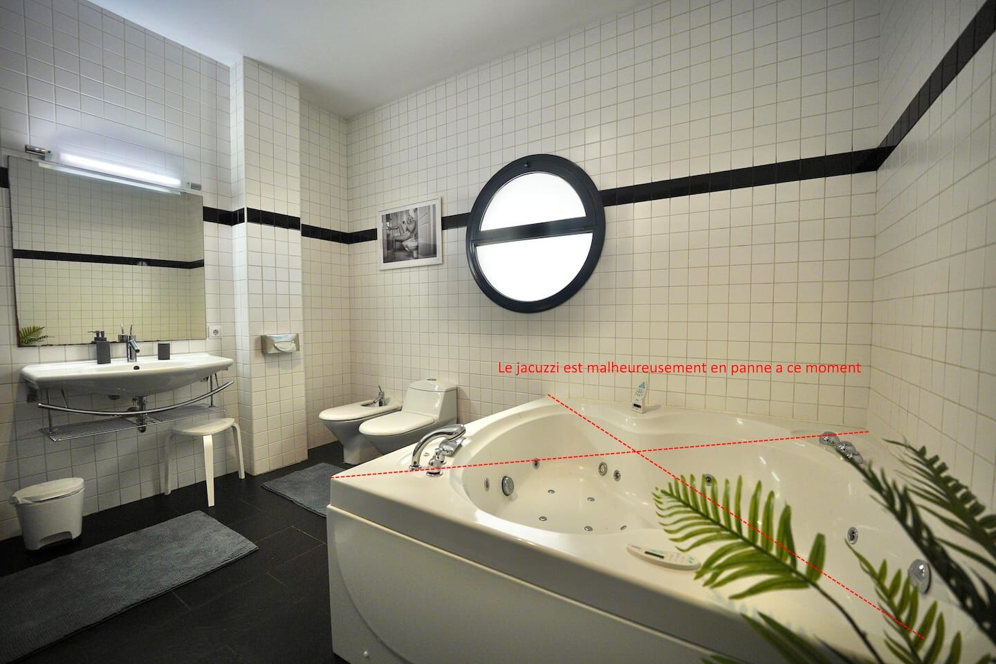 A modern bathroom with a large bathtub, a sink, and a toilet.