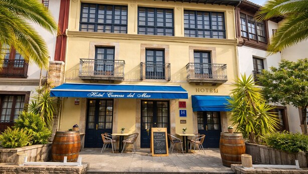 A hotel with a blue awning, outdoor seating, and palm trees. - HOTEL CUEVAS DEL MAR (Nueva)