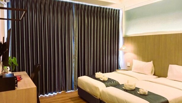 A hotel room with a bed, bedside tables, a desk, and a curtain. - Eastique Hotel Koh Chang (Ko Chang)