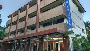 A multi-story hotel with a prominent sign, balconies, and a covered entrance area. - Eastique Hotel Koh Chang (Ko Chang)