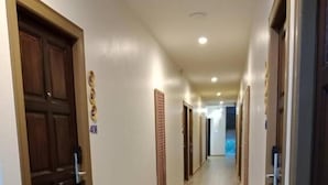 A hotel corridor with wooden doors, a light-colored floor, and a sign indicating room number 403. - Eastique Hotel Koh Chang (Ko Chang)