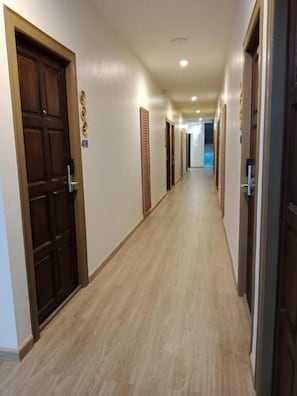 A hotel corridor with wooden doors, a light-colored floor, and a sign indicating room number 403. - Eastique Hotel Koh Chang (Ko Chang)