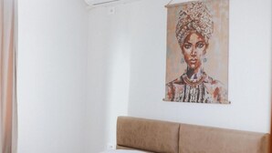A bedroom with a bed, a headboard, and a wall-mounted painting. - Villa Reve de Tirana (Tirana)