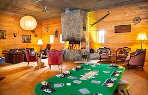 A cozy room with a fireplace, wooden walls, and a green felt table for card games. - Bendorfer Stadl Whirlpool-sauna-billard-kicker (Bendorf)
