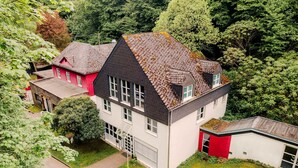 A multi-story house with a sloped roof, a small attached garage, and a well-maintained lawn. - Rheinsteig Chalet Whirlpool-sauna-billard-kicker (Bendorf)