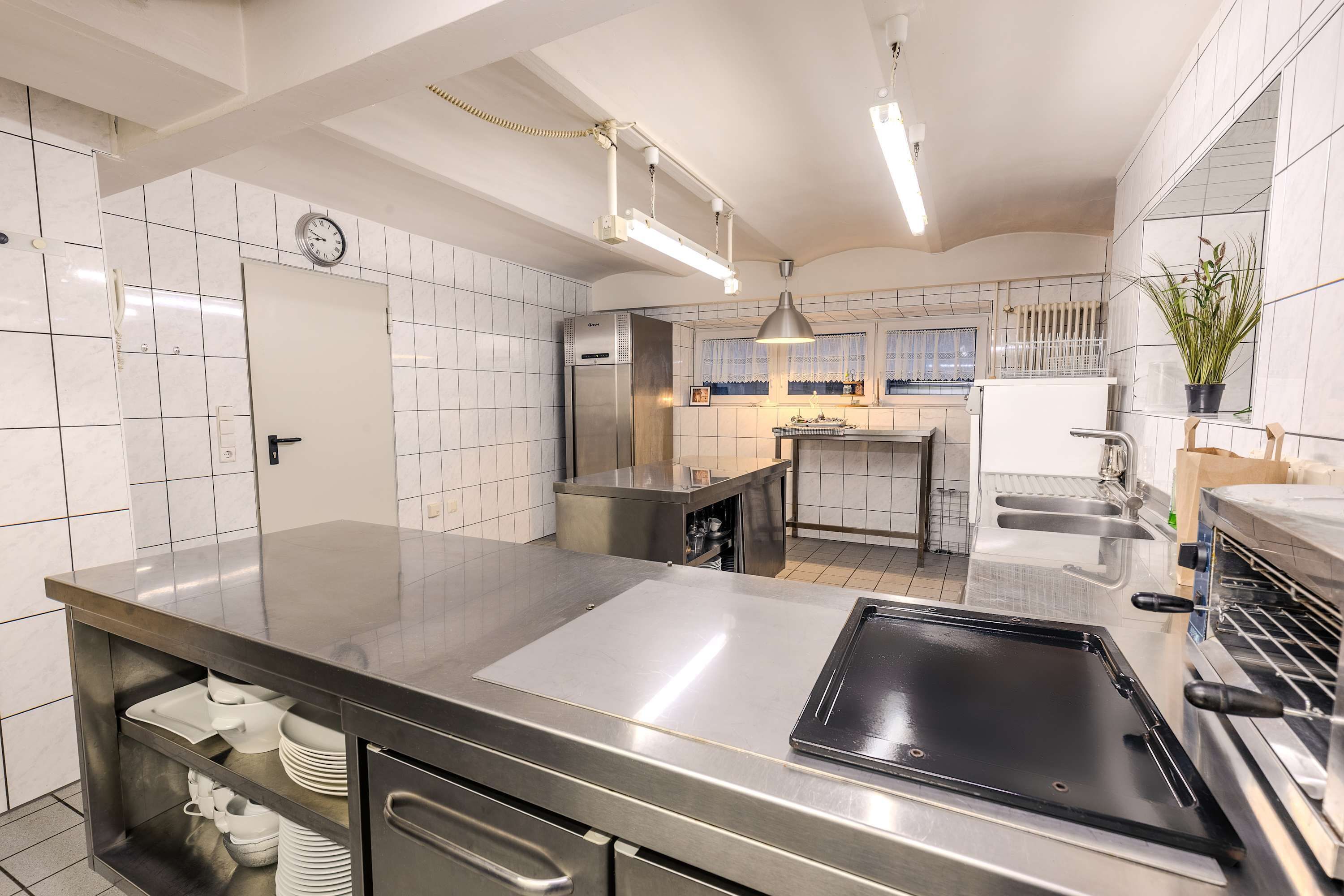 Una cocina moderna con electrodomésticos de acero inoxidable, una encimera negra y un salpicadero de azulejos.
