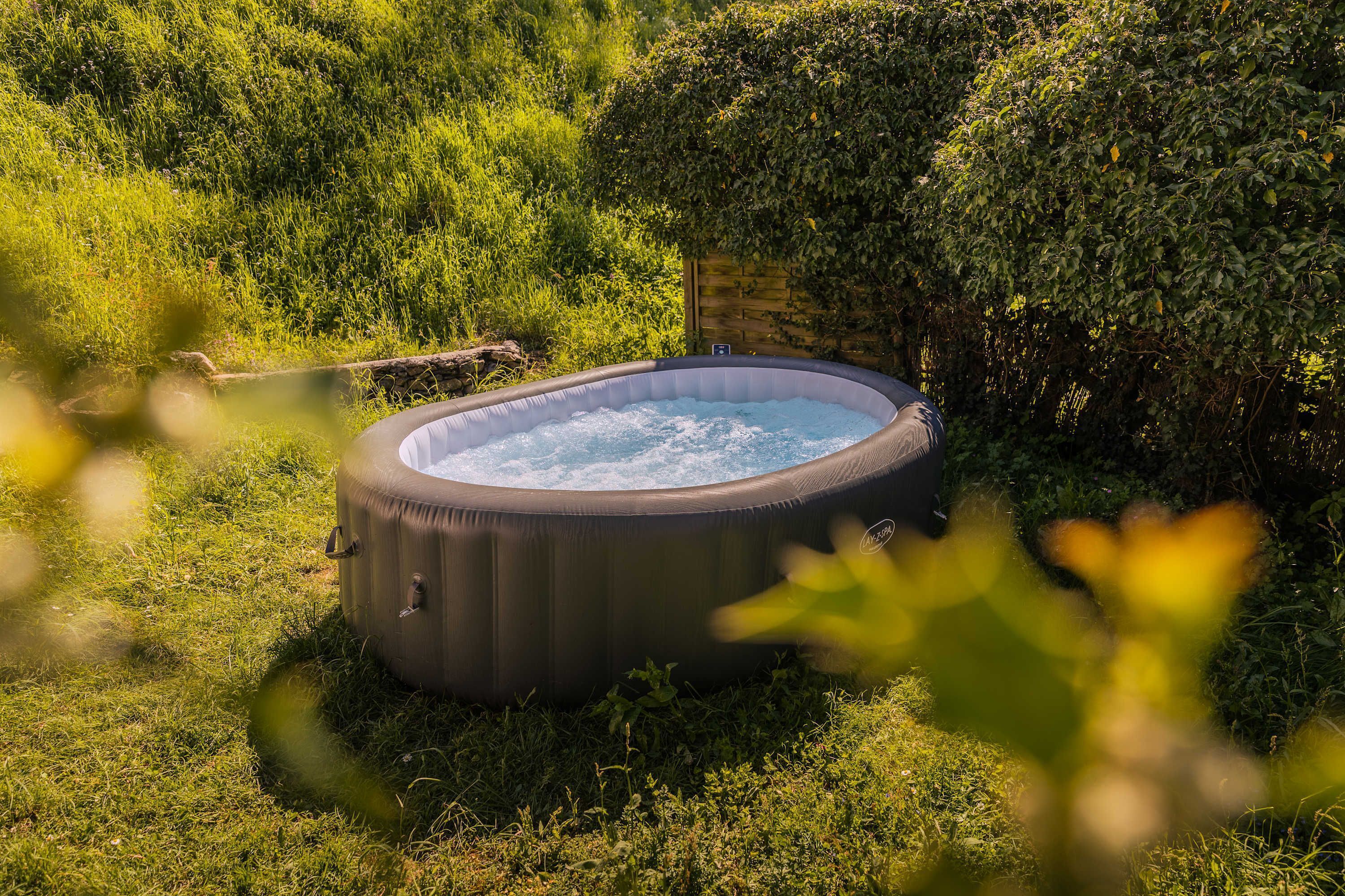 Ein Whirlpool in einer grünen Wiese mit einer Holzkonstruktion in der Nähe.