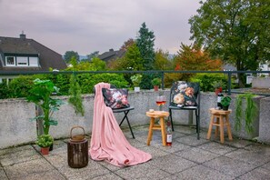 A rooftop terrace with a chair, a small table, a lantern, and potted plants. - Stilvolle Wohnung mit Balkon in Horchheim (Koblenz)