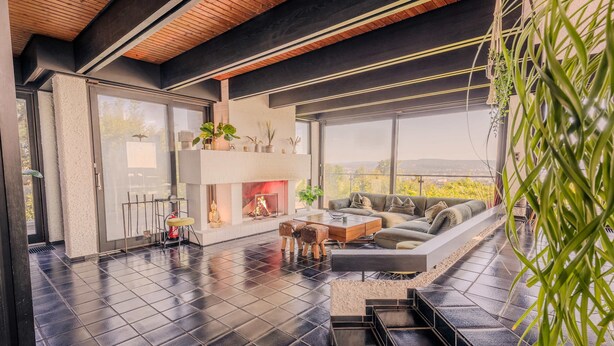 A modern living room with a fireplace, a sofa, and a coffee table. - Villa Panoramica Pool Sauna (Weitersburg)
