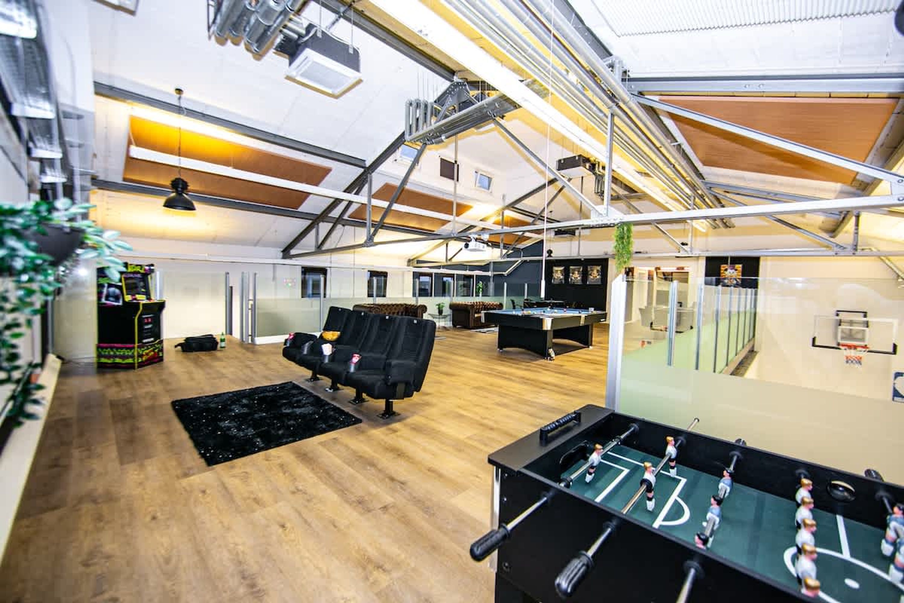 A spacious indoor area with a pool table, seating, and a foosball table.