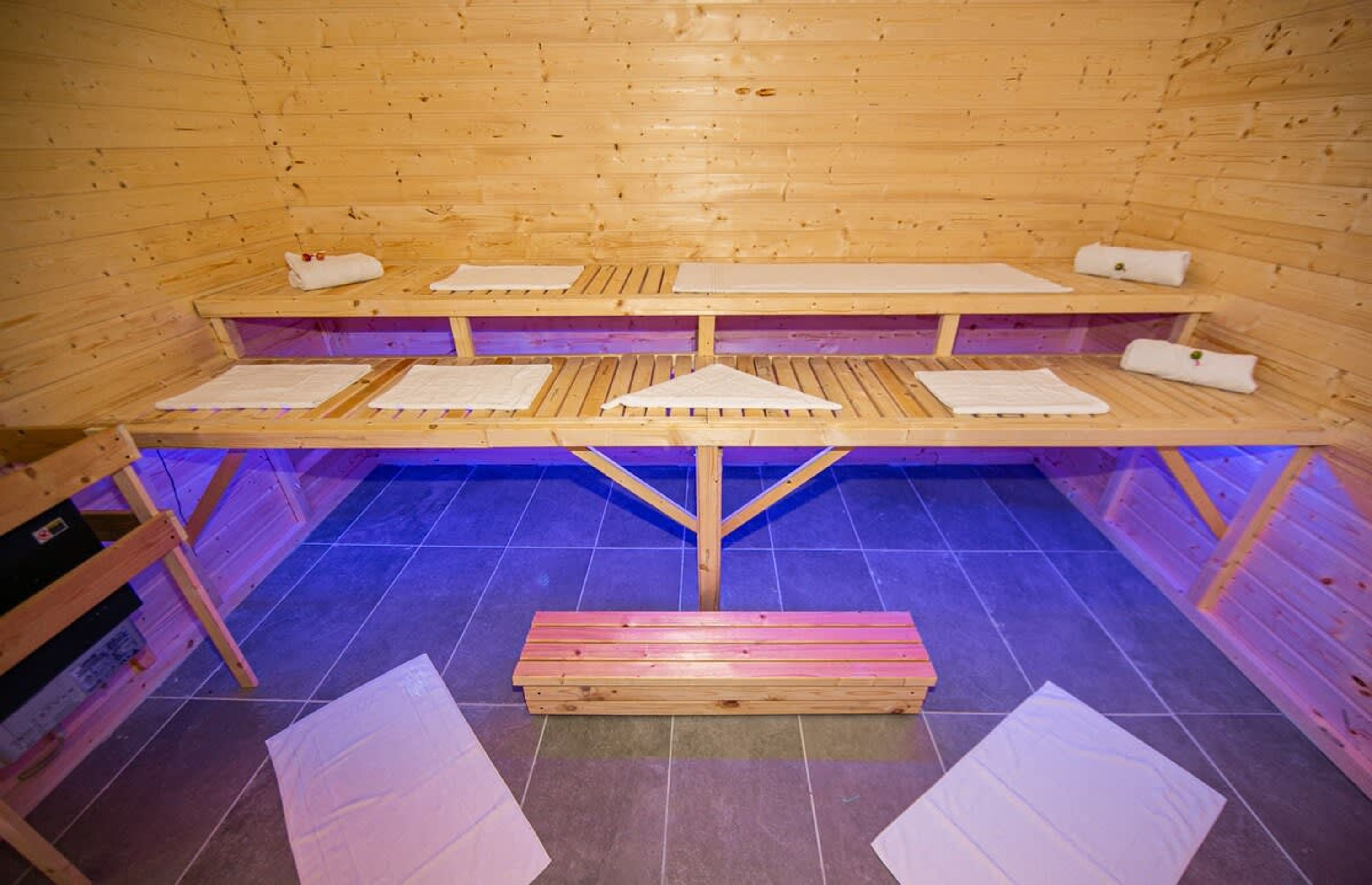 En sauna med træbænke og fliser.