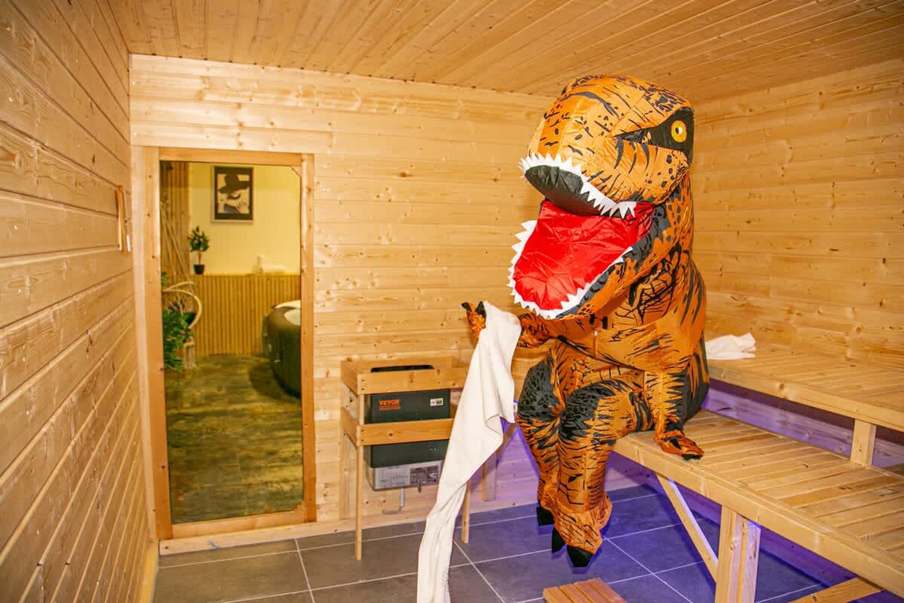 Eine Dinosaurierstatue in einem Holzraum mit einer Bank und einem Heizkörper.