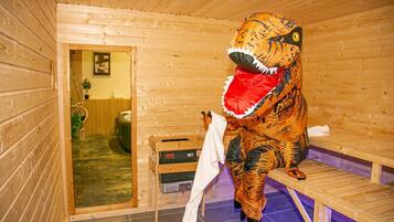 Eine Dinosaurierstatue in einem Holzraum mit einer Bank und einem Heizkörper.