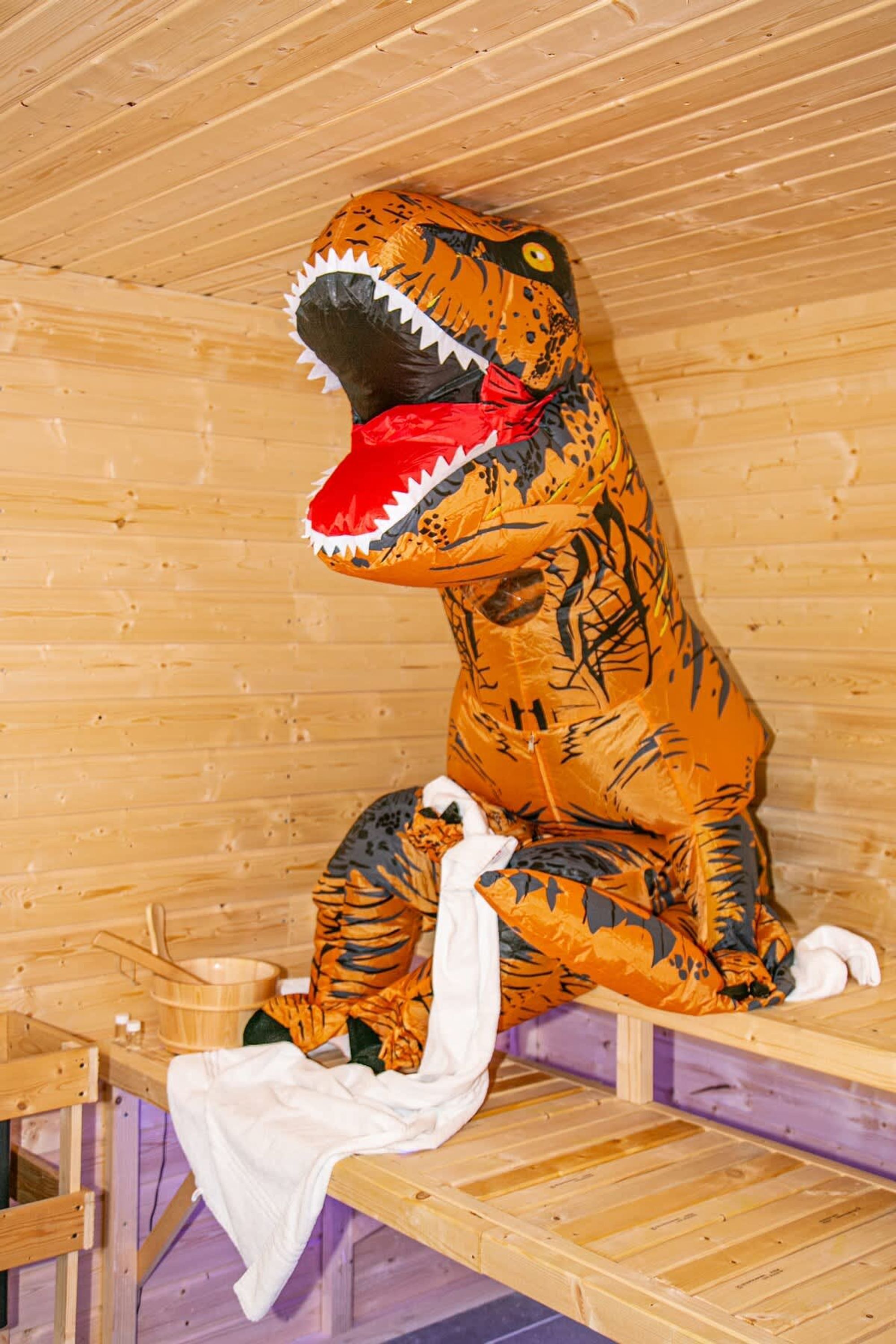 Una habitación temática de dinosaurios con detalles de madera, un banco y una bañera.