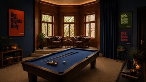 A pool table with balls, two leather armchairs, a small table with a candle, and a bookshelf. - Besto Residence Kino-billard-poker-kicker (Albstadt)