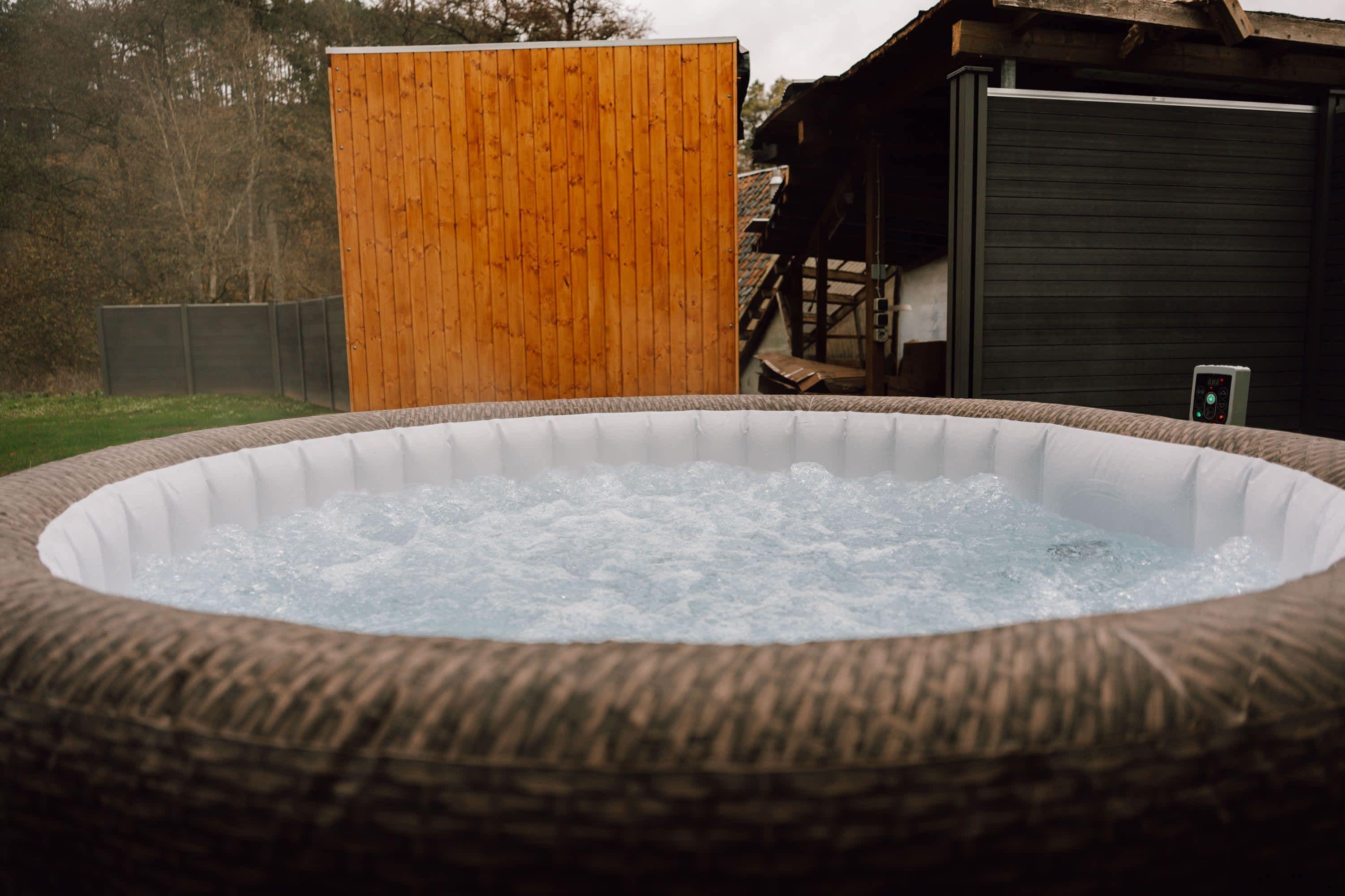 A hot tub with a wooden structure in the background.