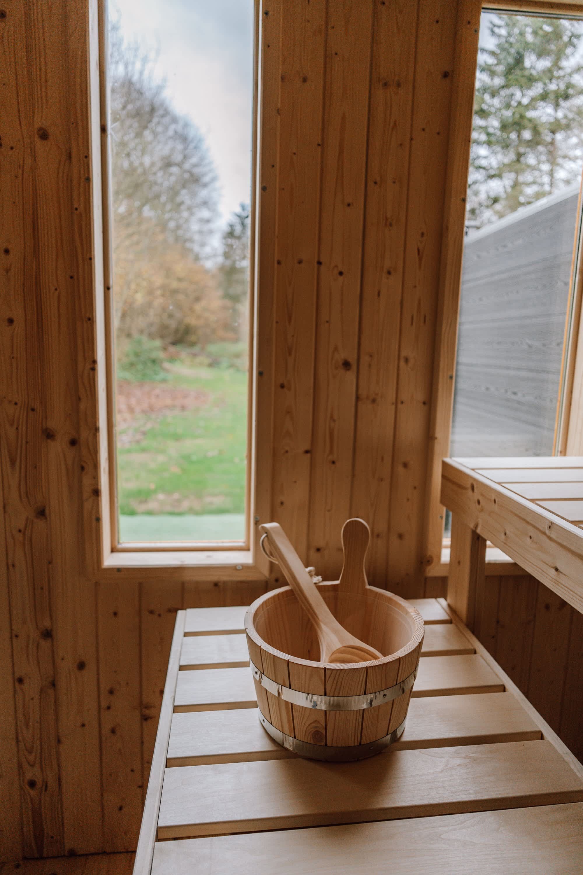 A wooden interior with a window, a wooden table, and a wooden bowl with a spoon.
