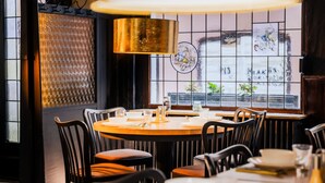Un restaurante con una mesa redonda, sillas y un amplio ventanal con vistas.