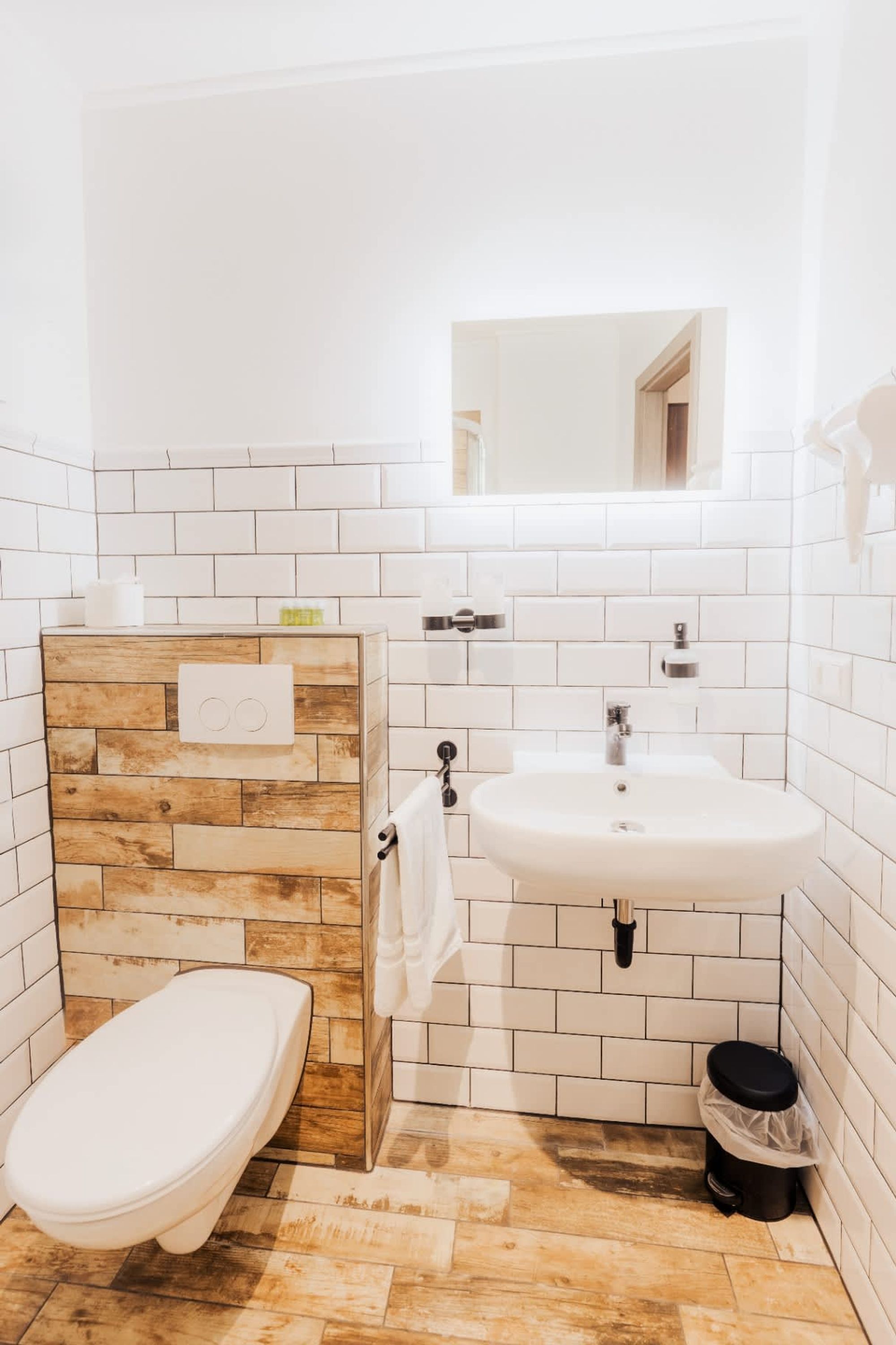Ein Badezimmer mit einem Holzbadezimmerhocker, einem weißen Waschbecken und einer Toilette.