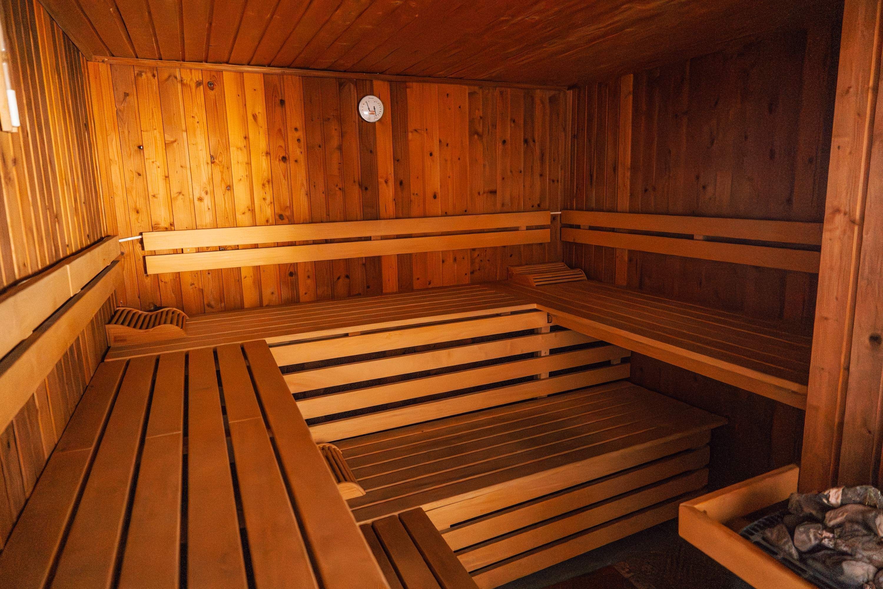 A sauna with wooden benches and a clock on the wall.