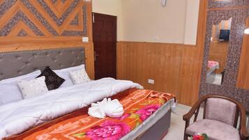 A bedroom with a bed, a wooden headboard, a mirror, and a chair.