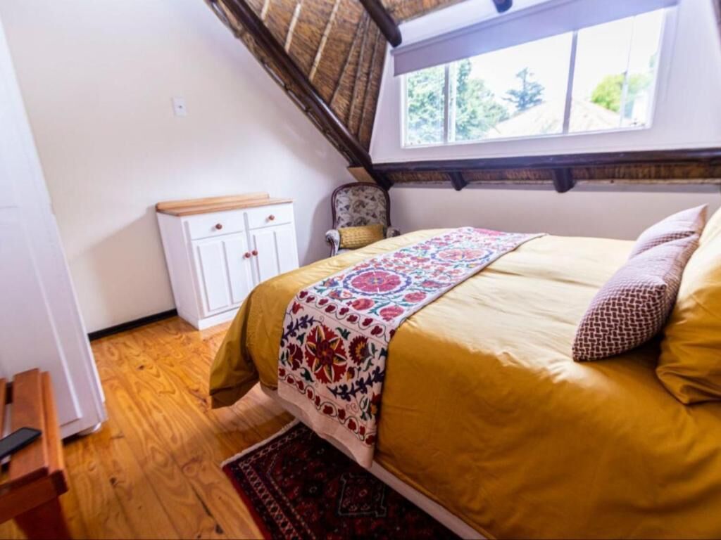 A bedroom with a bed, a window, a wardrobe, and a chair.