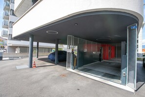 A modern building entrance with a covered area, a metal gate, and a number sign. - Urban Maggiolina Sunset With Terrace & Mountain Views (Locarno)