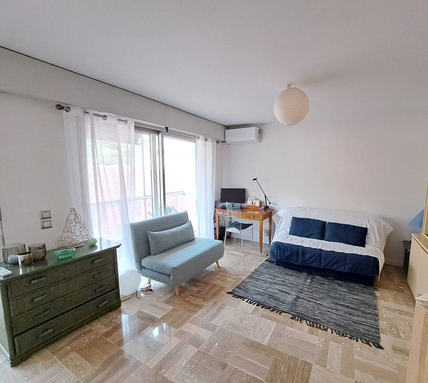 Ett sovrum med en säng, en soffa, ett skrivbord och en byrå.