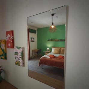 Een slaapkamer met een bed, een bureau en een stoel.