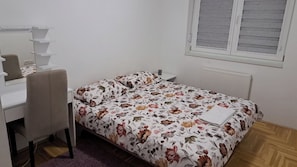 A bedroom with a bed, a desk, a chair, and a window. - Family-friendly 3-bedroom apartment with AC near Jahorina in Sarajevo (Sarajevo)