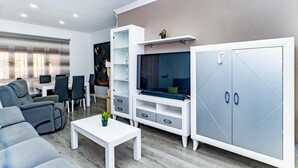 A modern living room with a sofa, a coffee table, a TV, and a cabinet.