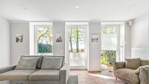 Ein Wohnzimmer mit zwei Sofas, einem Couchtisch und Blick durch große Fenster.