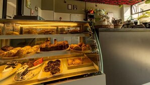 A bakery display with various baked goods, a decorative ceiling, and a bear statue. - Cozy,all-equipped 1-bedroom apartment with cafe,gym &minimart in Uptown Nairobi. (Nairobi)