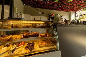 A bakery display with various baked goods, a decorative ceiling, and a bear statue. - Cozy,all-equipped 1-bedroom apartment with cafe,gym &minimart in Uptown Nairobi. (Nairobi)