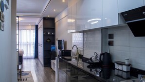 A modern kitchen with a microwave, coffee maker, and a water dispenser. - Cozy,all-equipped 1-bedroom apartment with cafe,gym &minimart in Uptown Nairobi. (Nairobi)