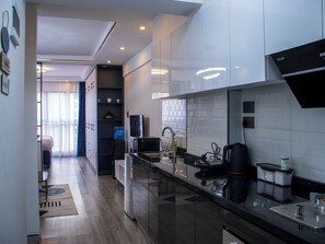A modern kitchen with a microwave, coffee maker, and a water dispenser. - Cozy,all-equipped 1-bedroom apartment with cafe,gym &minimart in Uptown Nairobi. (Nairobi)