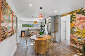 A modern kitchen with a dining area, featuring a round table, chairs, and pendant lighting. - Whimsical Palm Springs Retreat - A Ryson Property (Palm Springs)