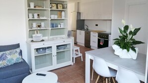 A compact living space with a kitchenette, a dining area, and a sofa.