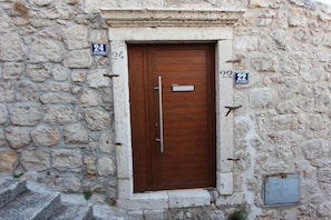 A stone building with a wooden door, numbered 24 and 22. - Studio Talir with terrace (Dubrovnik)