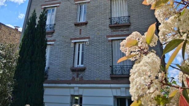 Un immeuble à plusieurs étages, doté d’une façade en briques, de nombreuses fenêtres et de balcons.