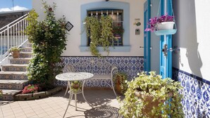 A terrace with a white table, a bench, and potted plants. - Apartment 'La Maison Des Artistes' with Wi-Fi and Air Conditioning (Mozzecane)