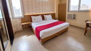 A bedroom with a bed, a wardrobe, a nightstand, and a window. - OnlyStay Snap Hotel (Noida)
