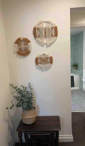 Un mur orné de trois œuvres d’art murales de forme circulaire et une plante en pot posée sur une table.