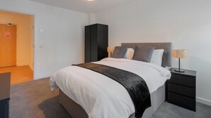 Una camera da letto moderna con un letto, un comodino e un armadio.