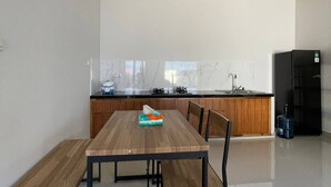 Una cocina moderna con una mesa de comedor de madera, sillas y un dispensador de agua.